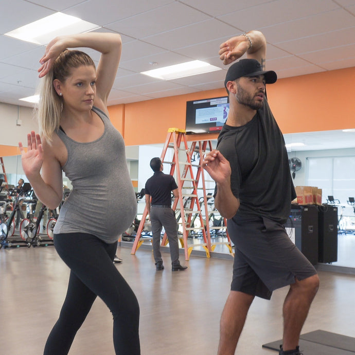 Coach and mom exercising in a gym

